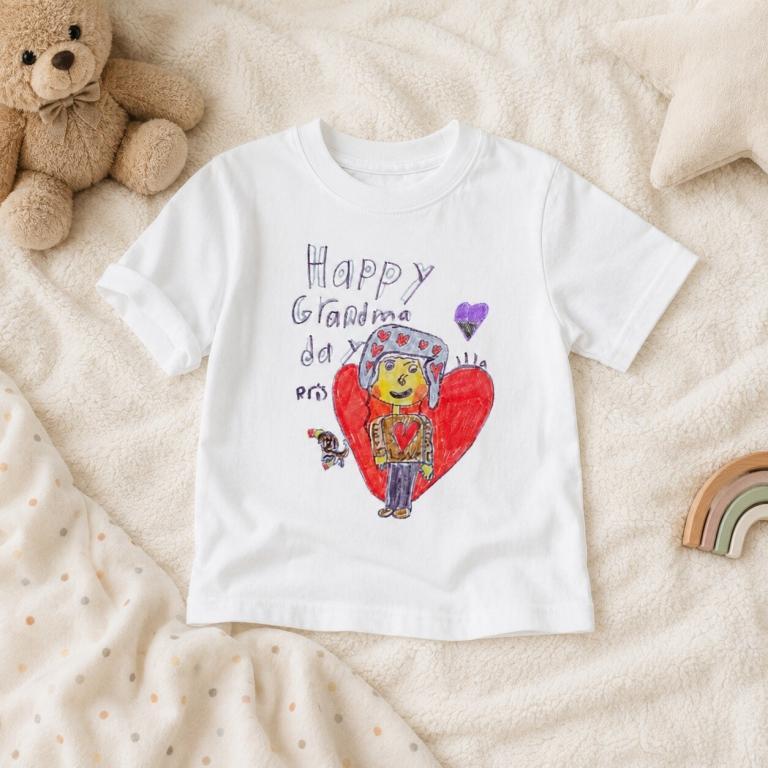 White t-shirt featuring child’s drawing with hearts and "Happy Grandma" message